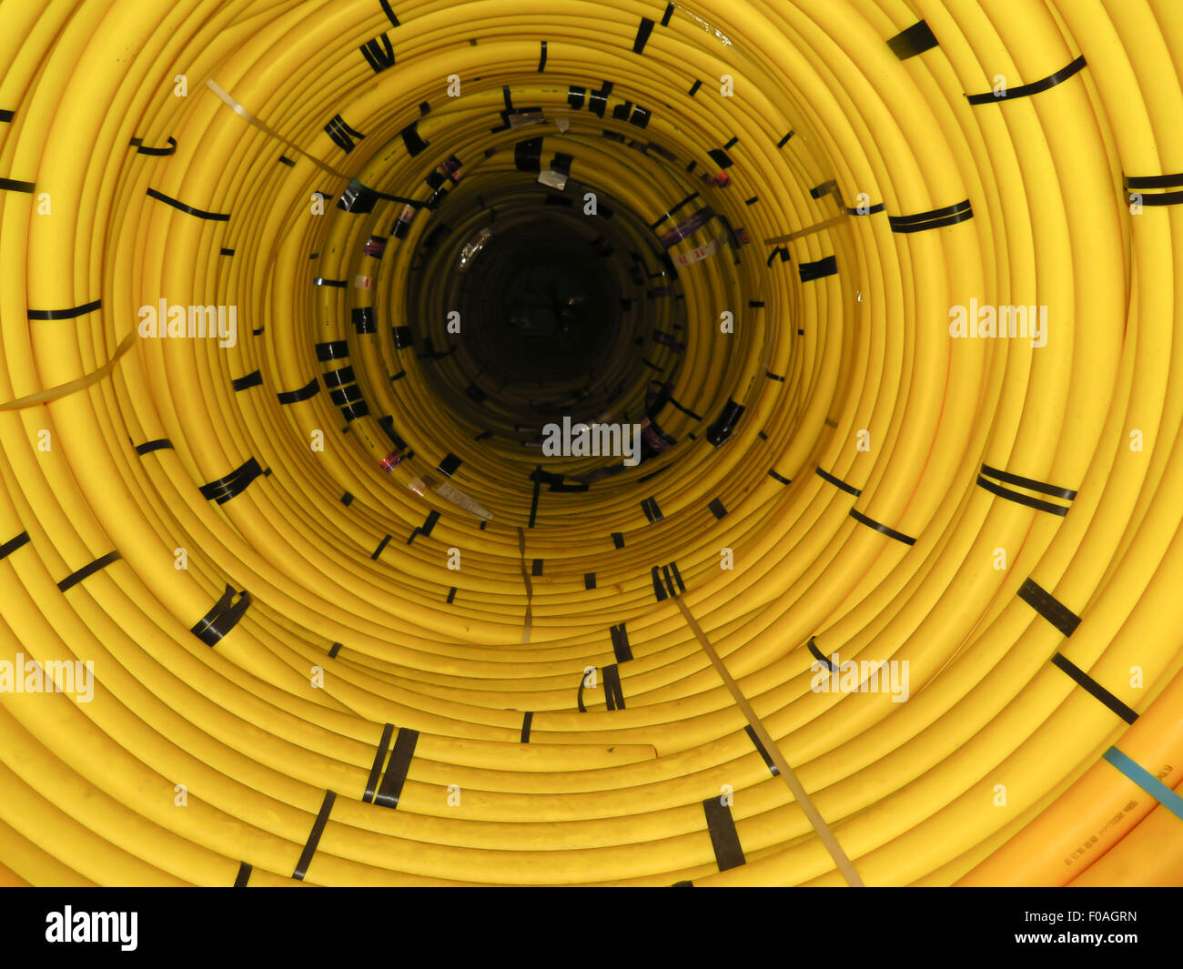 Coil of yellow plastic pipe creating abstract pattern Stock Photo