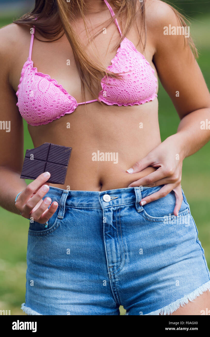 Closeup portrait of Young woman with chocolate showing her fat Stock Photo