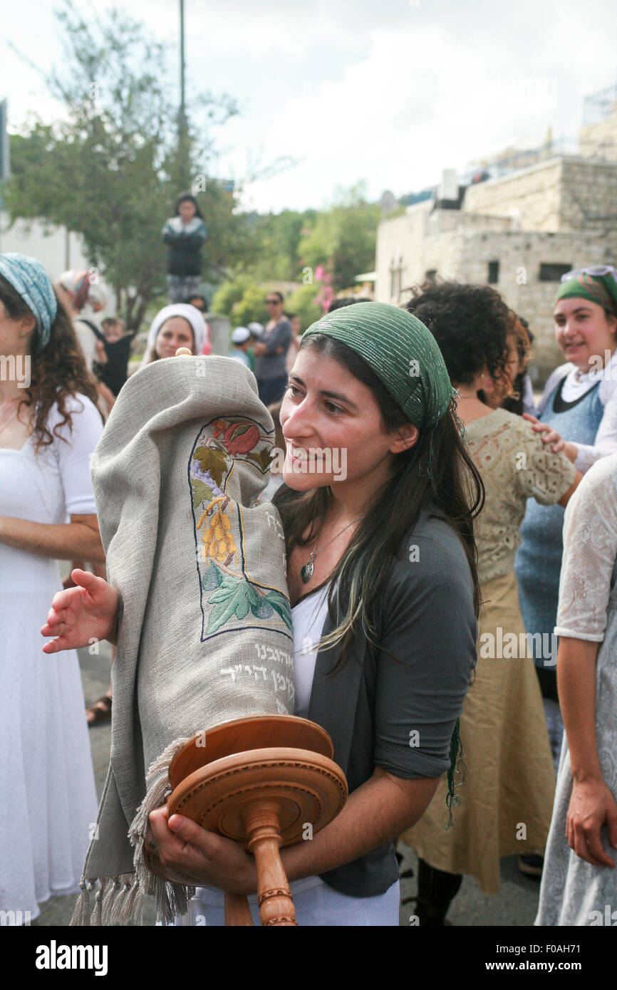 A new Torah Scroll is brought into a synagogue while the onlookers celebrate the event with dances and songs Stock Photo