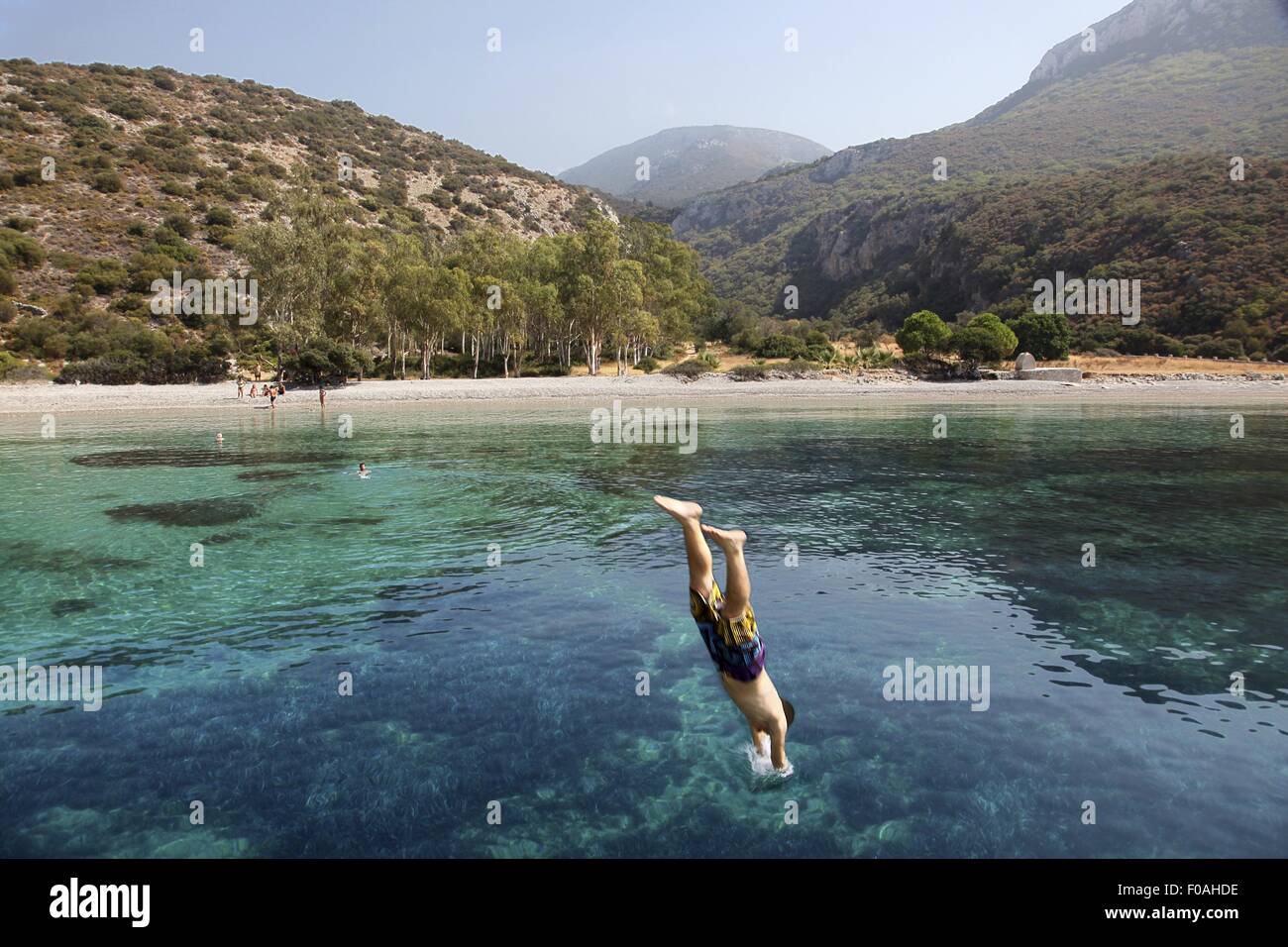 Man diving into Aegean sea near Resadiye peninsula in Turkey Stock