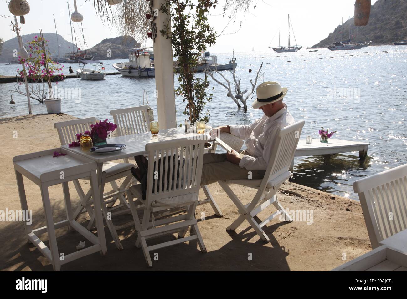 man sitting in mimoza restaurant in gumusluk bodrum peninsula aegean region turkey stock photo alamy