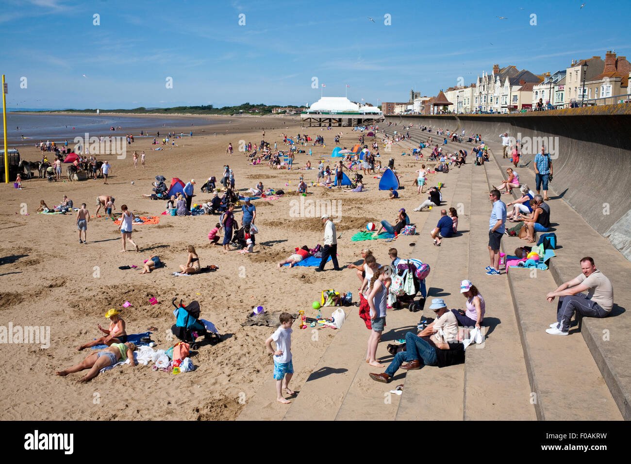 holiday makers enjoying the sunshine on the beach in Burnham on sea Somerset uk Stock Photo