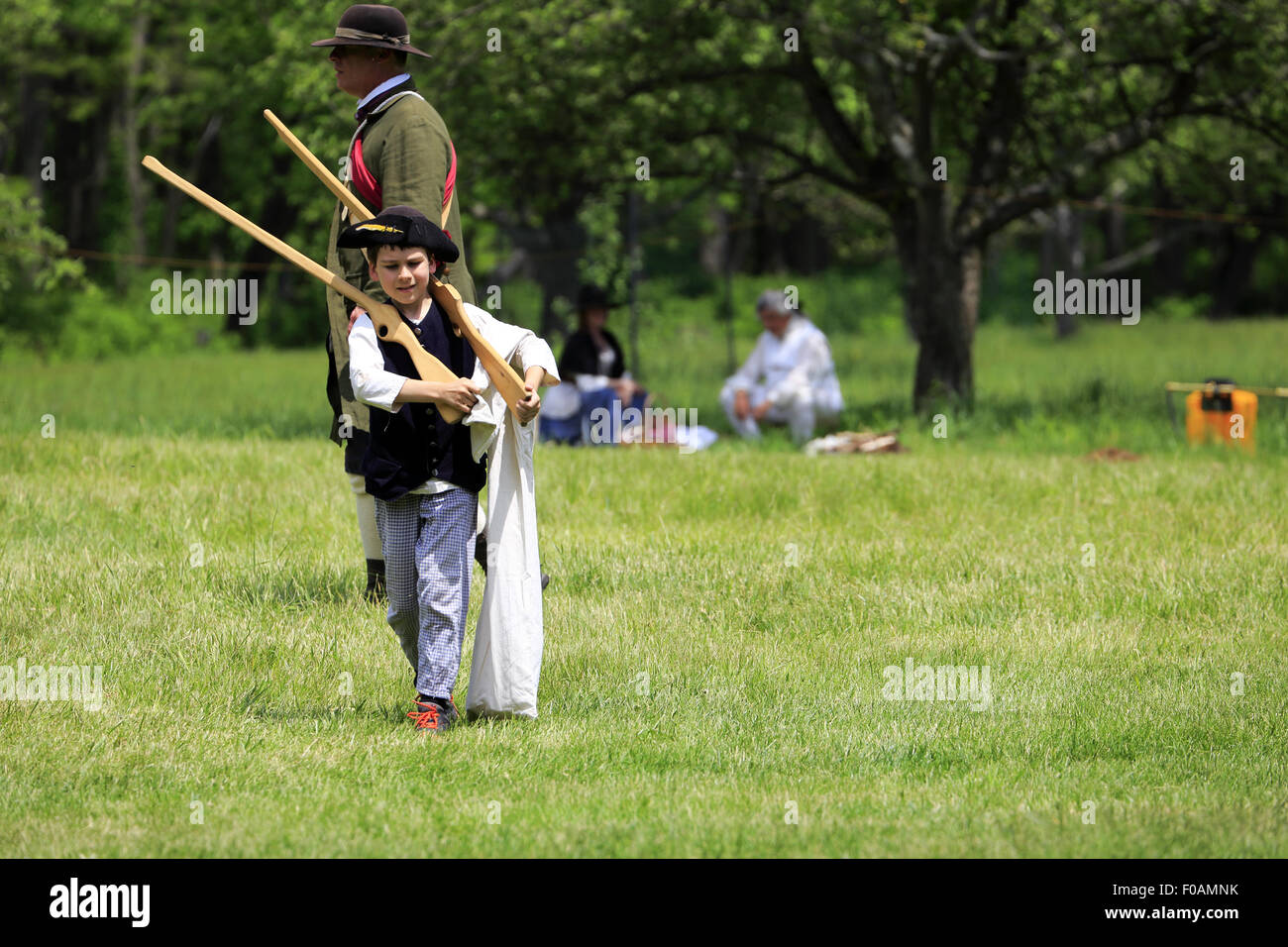 A child in clothes of colonial period with wooden riffles in Revolutionary War reenactment at Jockey Hollow Morristown NJ USA Stock Photo