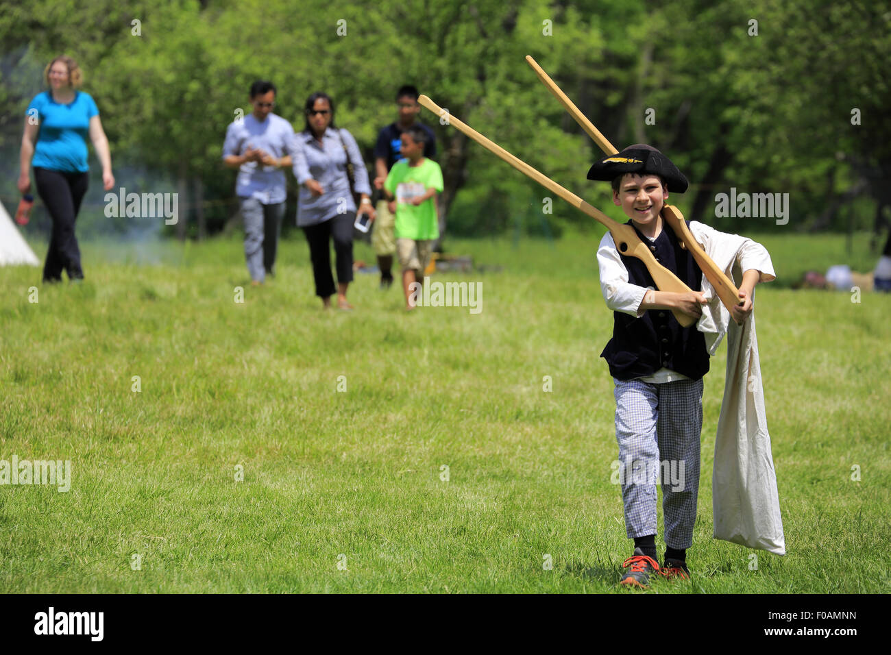 A child in clothes of colonial period with wooden riffles in Revolutionary War reenactment at Jockey Hollow Morristown NJ USA Stock Photo