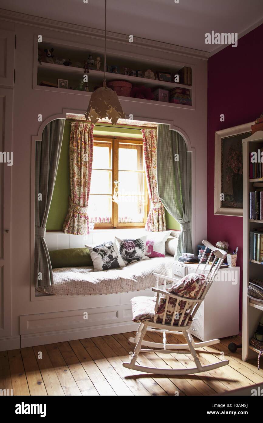 Bed, paneling, wooden, rocking chair and chest of drawers in girls room ...