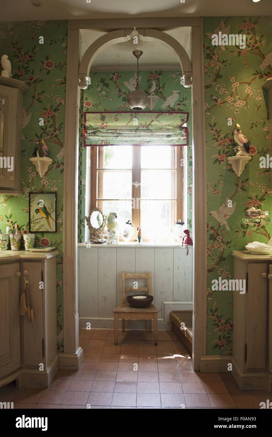 Wallpaper, floral motif, green, ceramics parrot, cockatoo, birds and consoles in room Stock Photo