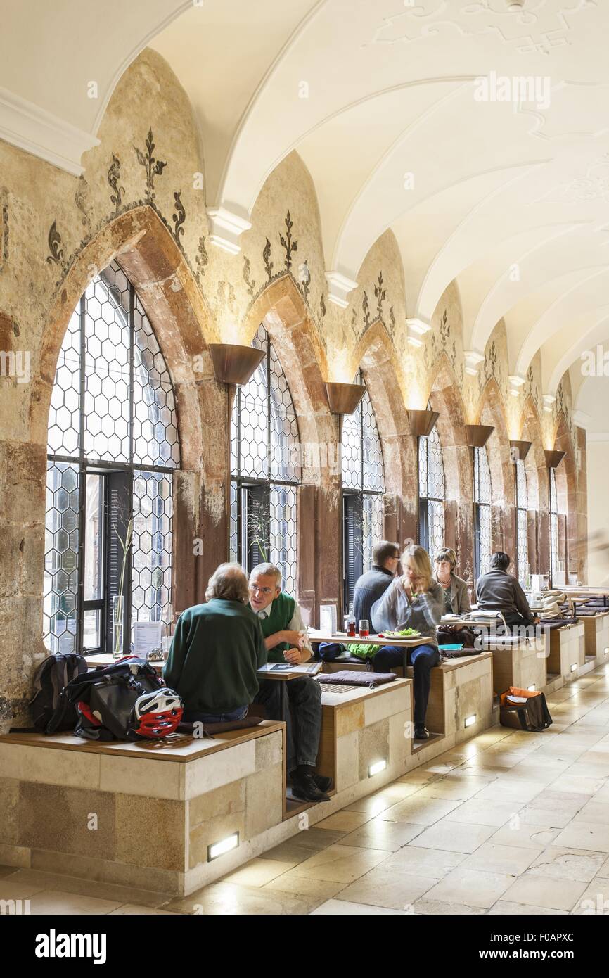 People sitting at Gothic cloister with cafe in Augustiner Museum, Freiburg, Germany Stock Photo