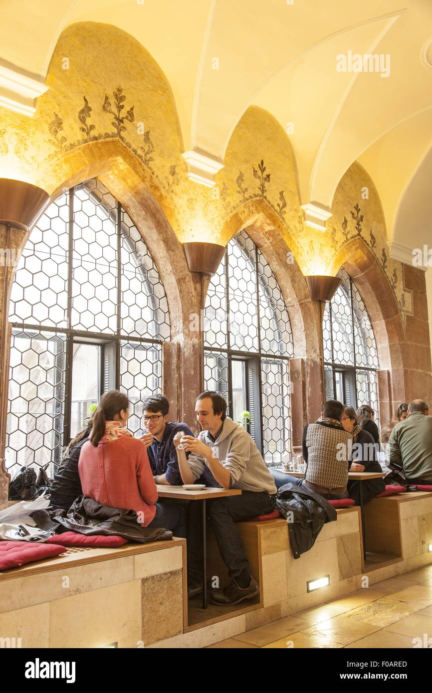 People sitting at Gothic cloister with cafe in Augustiner Museum, Freiburg, Germany Stock Photo