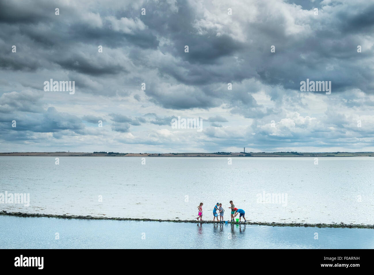 Canvey island - Children exploring on the foreshore at Canvey Island, Essex. Stock Photo