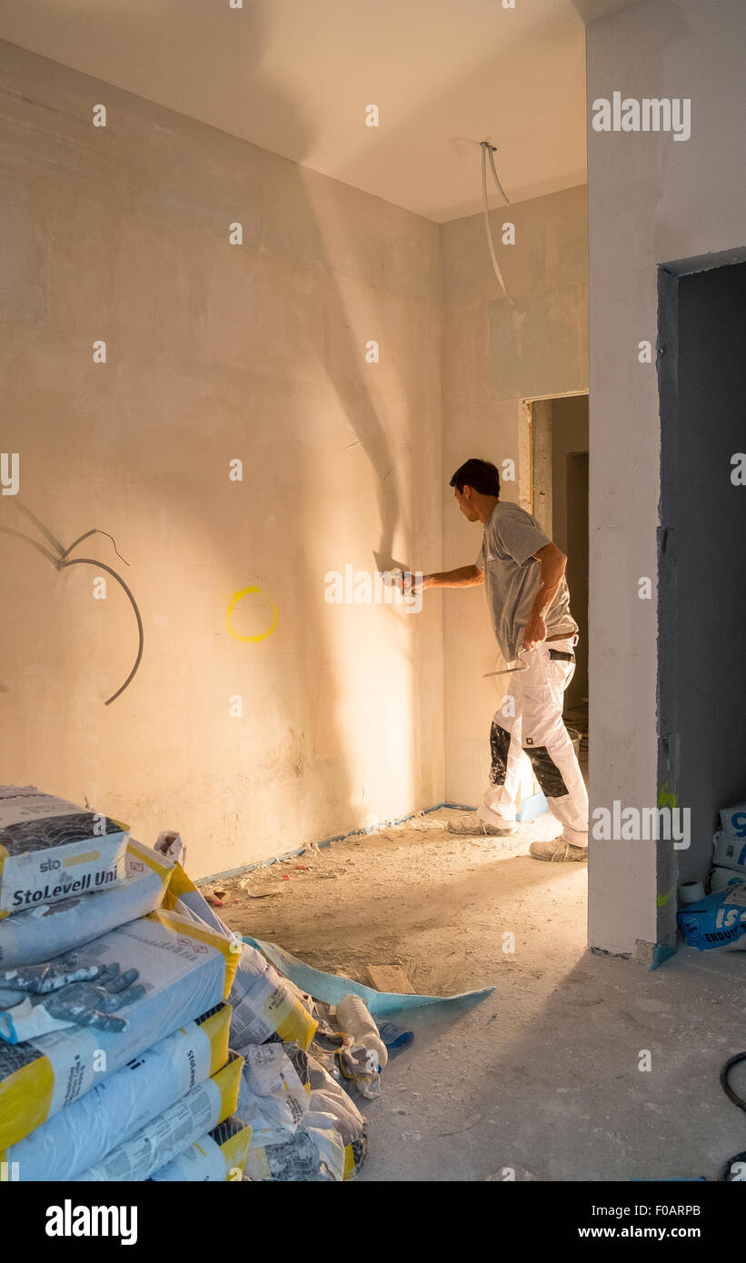 plasterer applying plaster wall working inside Stock Photo
