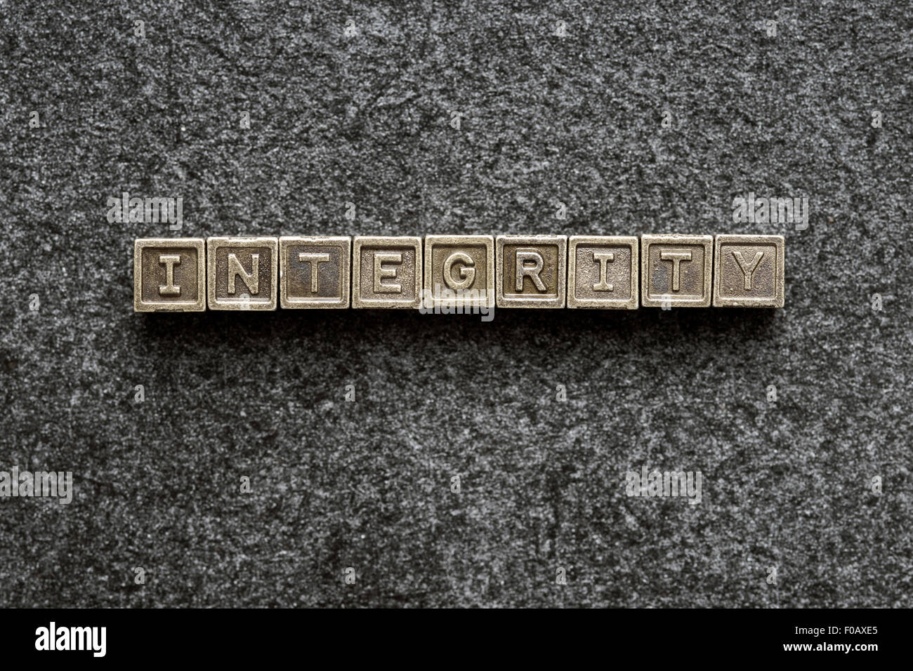 integrity word made from metallic blocks on blackboard surface Stock Photo