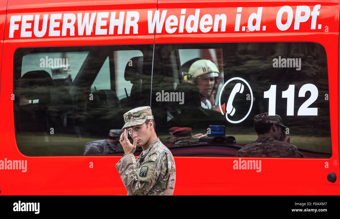 Engelmannsreuth, Germany. 11th Aug, 2015. A US soldier stands in front of a fire engine in Engelmannsreuth, Germany, 11 August 2015. An F-16 fighter aircraft of the US Air Force crashed near Engelmannsreuth. Photo: NICOLAS ARMER/dpa/Alamy Live News Stock Photo