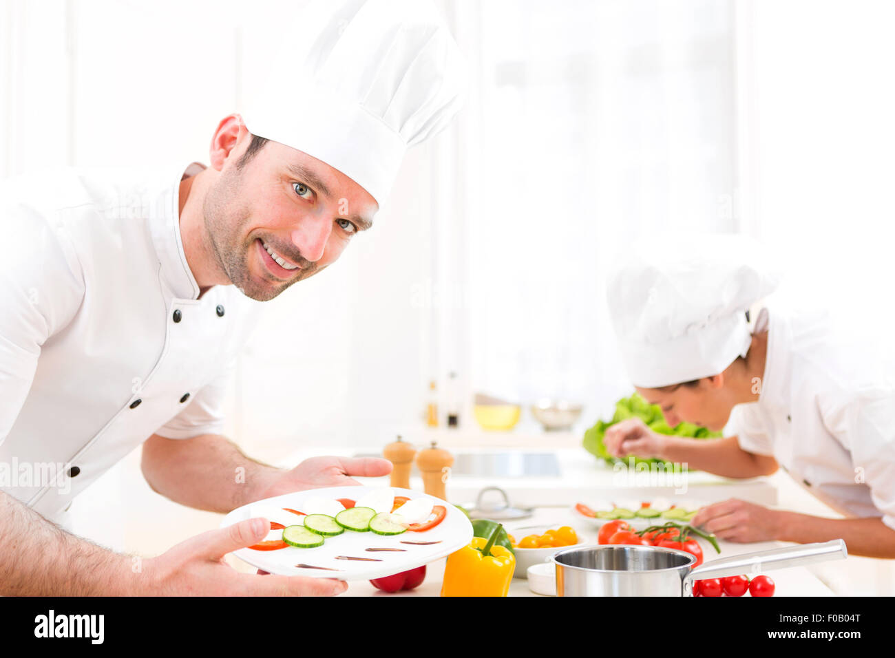 View of a Young attractive professional chef cooking in his kitchen Stock Photo