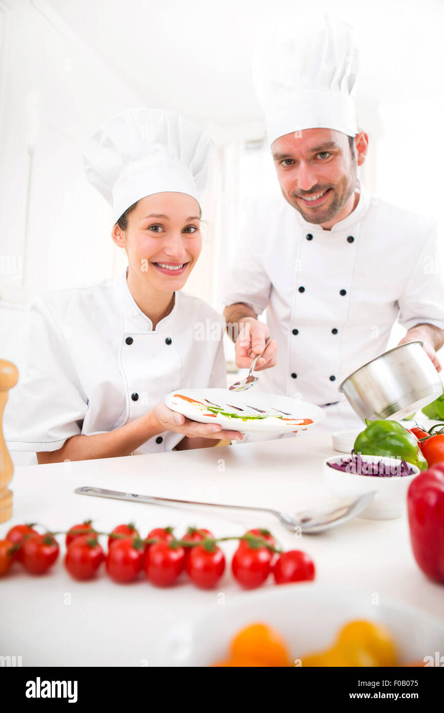 View of Young attractives professionals chefs cooking together Stock Photo