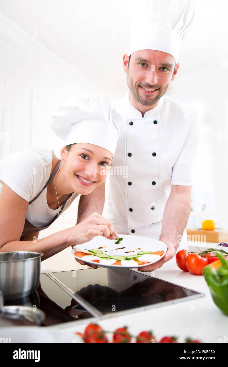 View of a Young chef training a young attractive girl to cook Stock ...