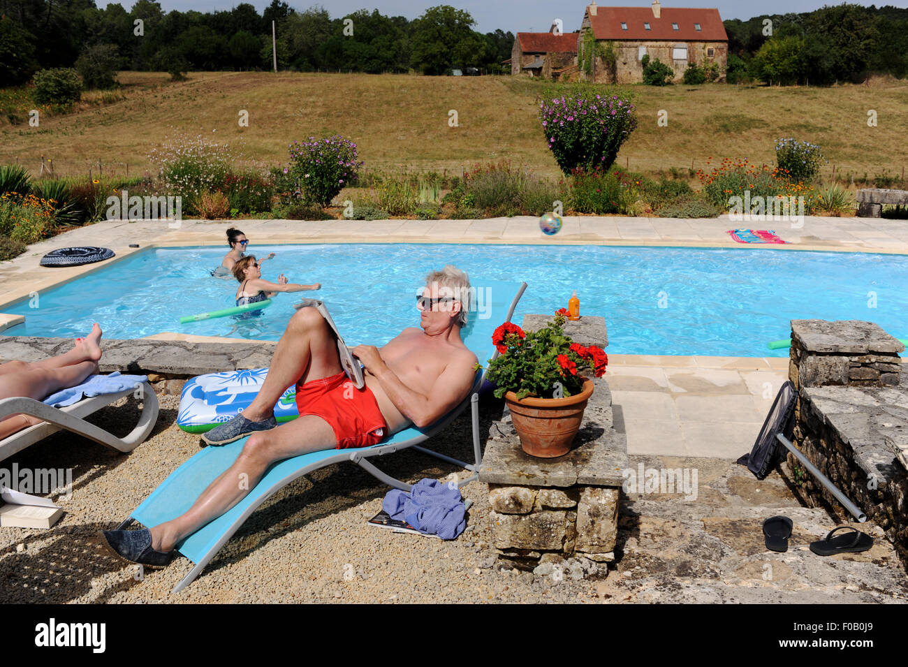 France Holiday 2015 to the Lot Region of South West France Europe Sunbathing by the pool at holiday gite in Frayssinet-le-Gelat Stock Photo