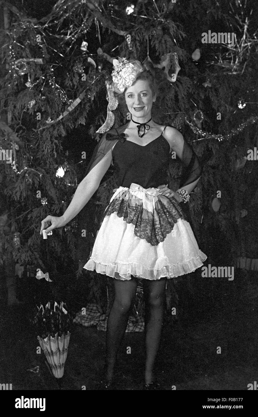 A woman wearing fancy dress standing in front of a Christmas tree Stock  Photo - Alamy