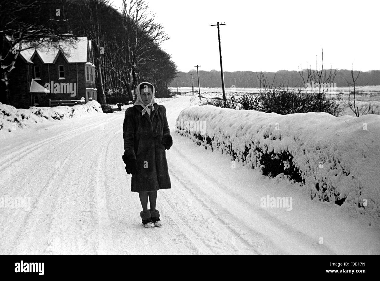 A woman standing on a snow-covered road Stock Photo