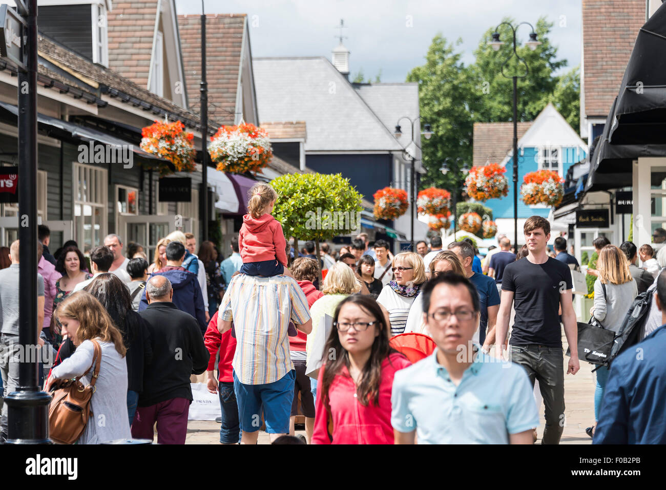 Busy street of shoppers at Bicester Village Outlet Shopping Centre