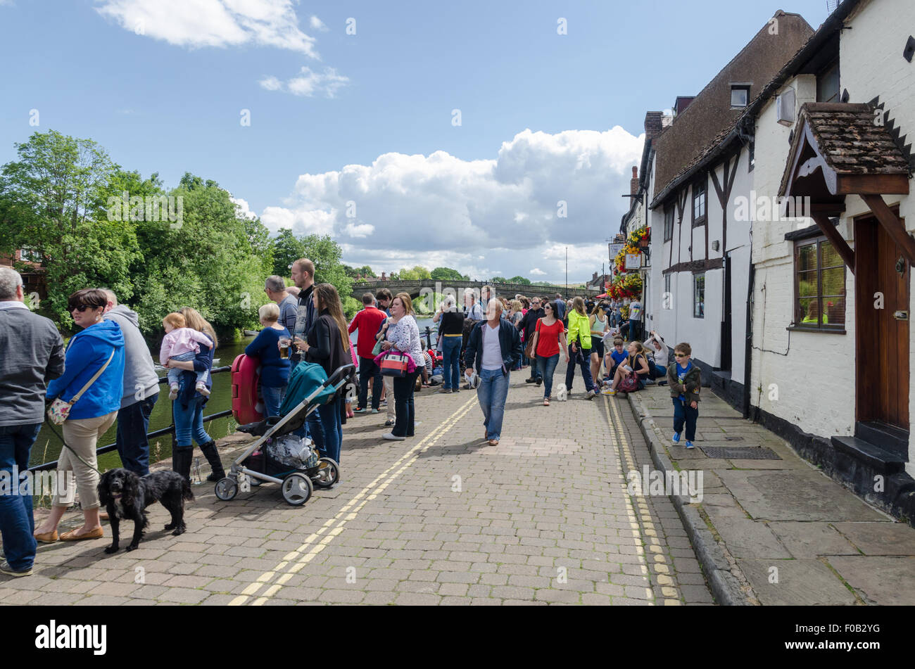 Visitors on the banks of the River Severn in the Worcestershire town of Bewdley watching the rowing regatta Stock Photo