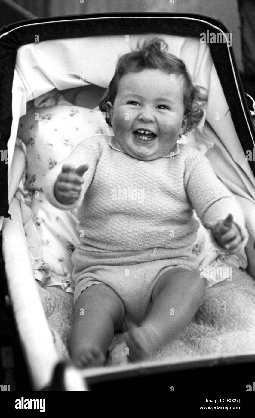 A child laughing in her pram. Stock Photo