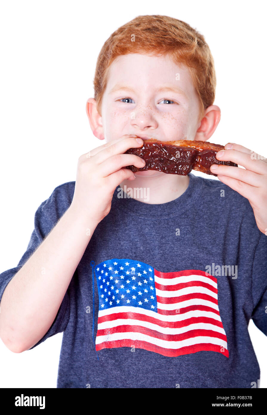 Hungry boy eating BBQ rib in studio Stock Photo