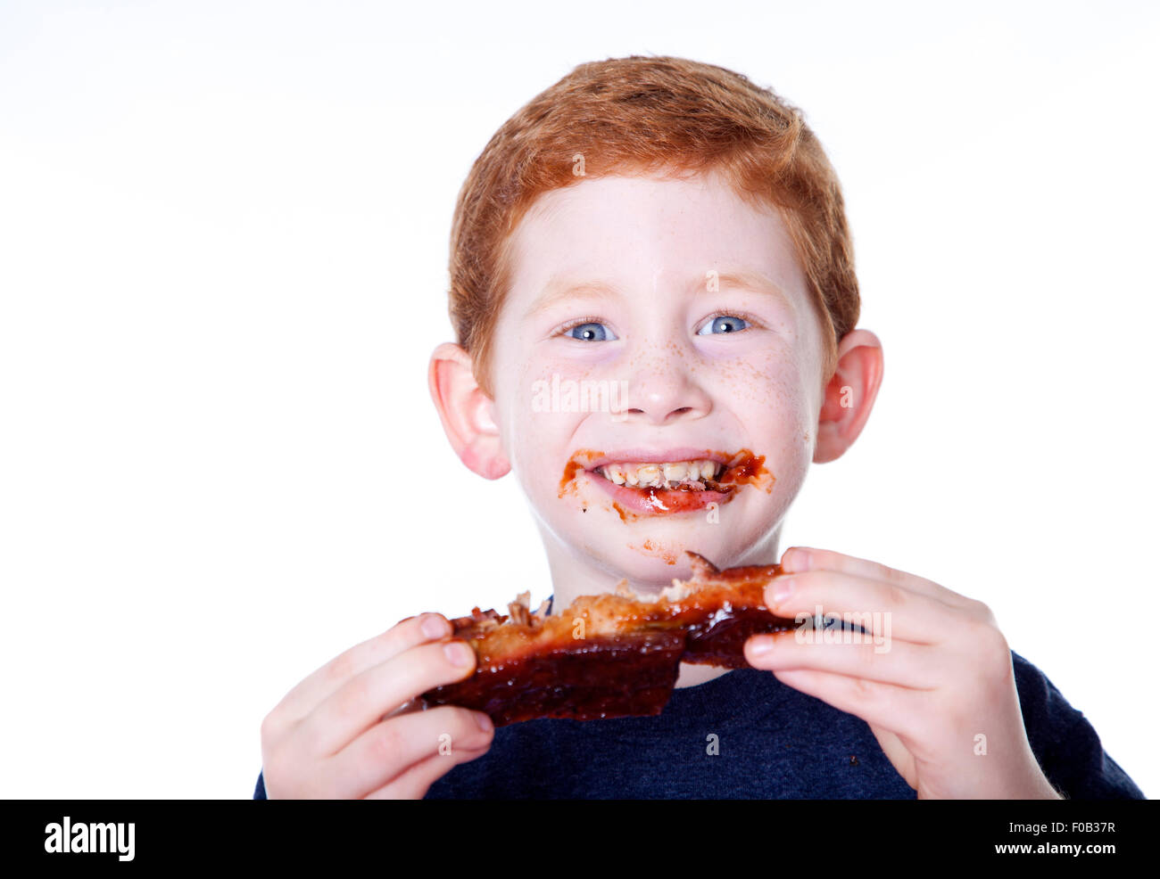 Hungry boy eating BBQ rib in studio Stock Photo Alamy
