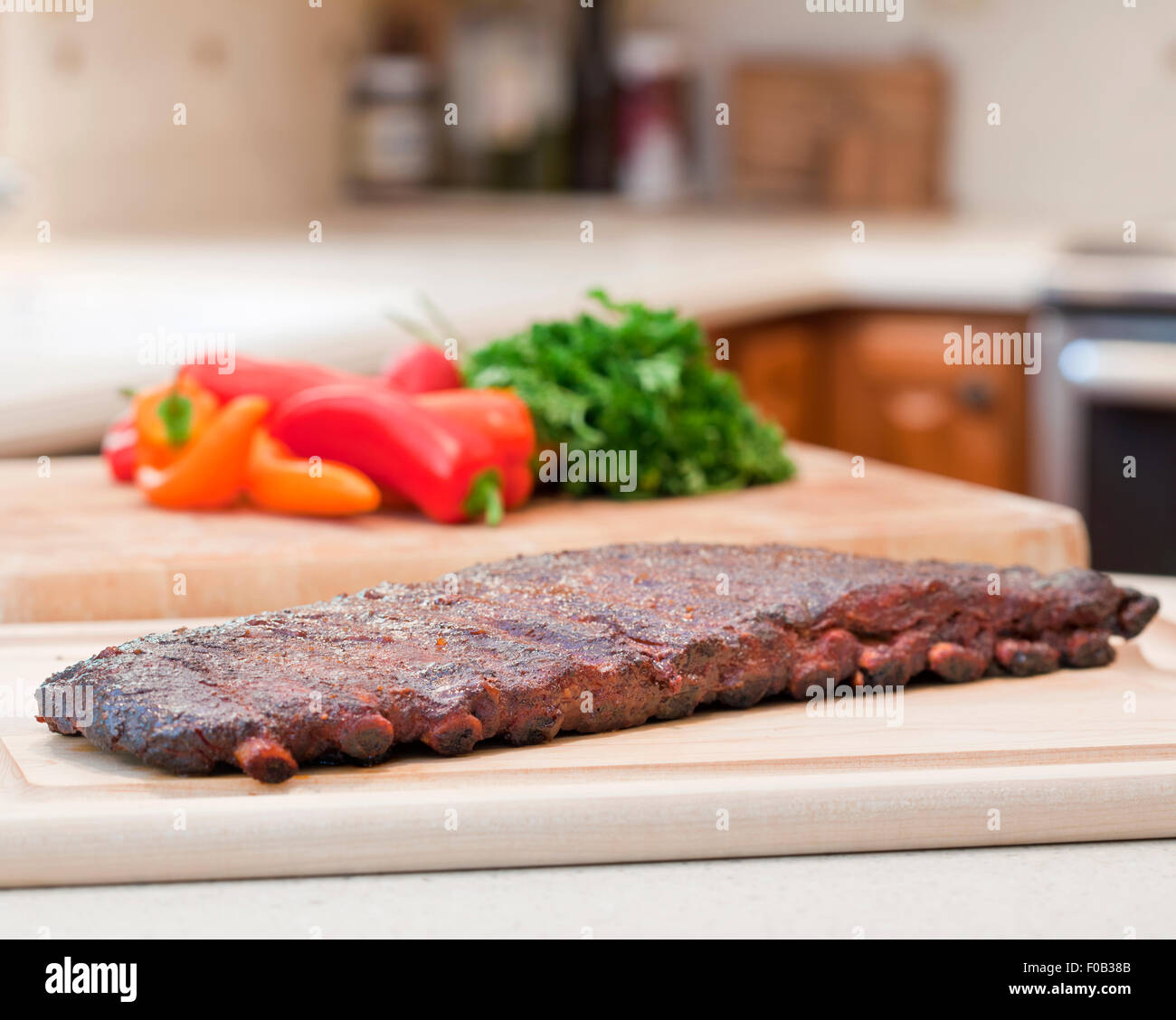Fresh BBQ ribs on a wooden chopping board in studio Stock Photo