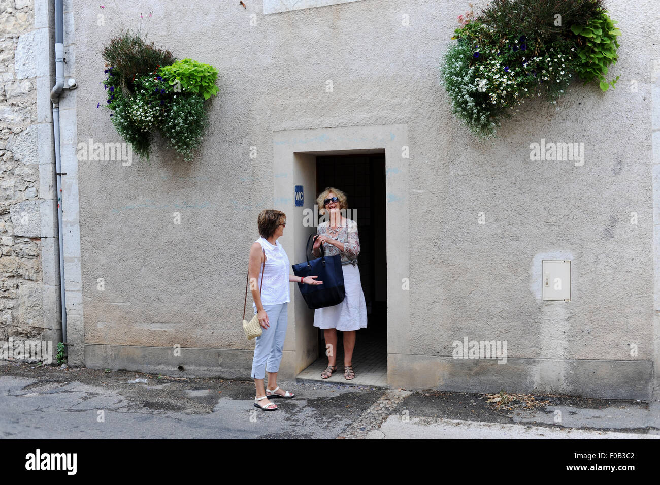 Tourists visiting public toilets at Douelle  a commune in the Lot department in south-western France Midi Pyrenees Stock Photo