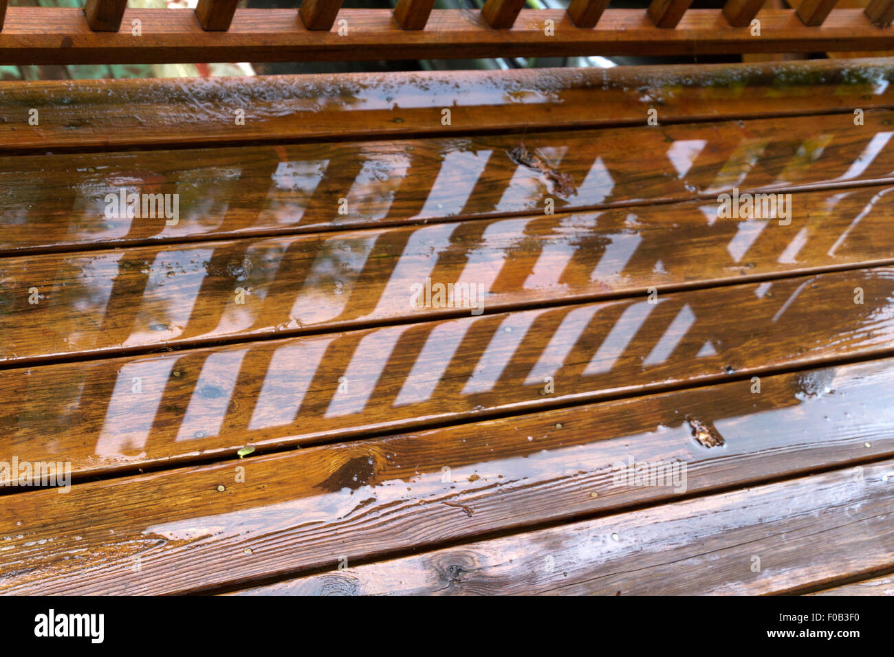 Close up of the wet and weathered wood boards of an outdoor deck after a summer rainstorm Stock Photo
