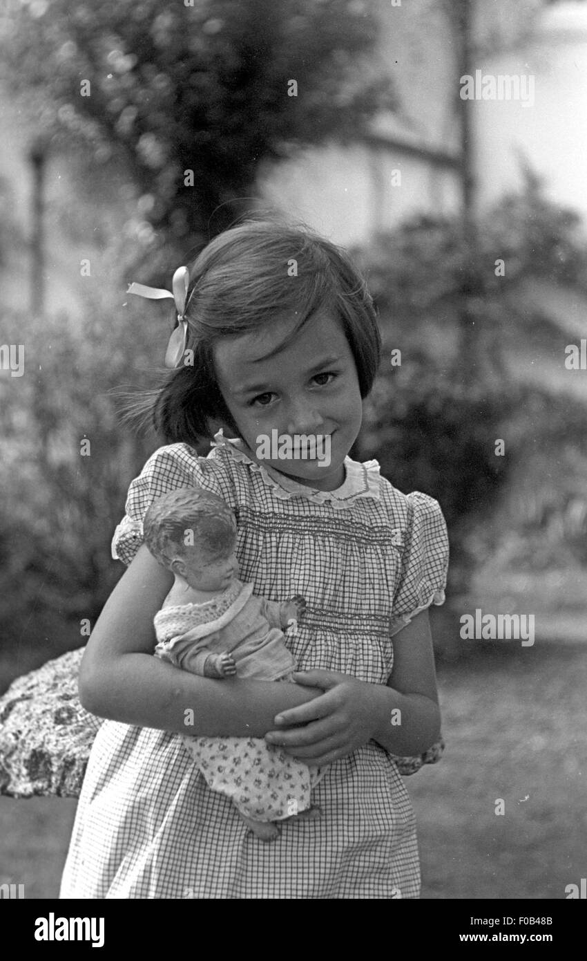A young girl carrying a doll Stock Photo Alamy