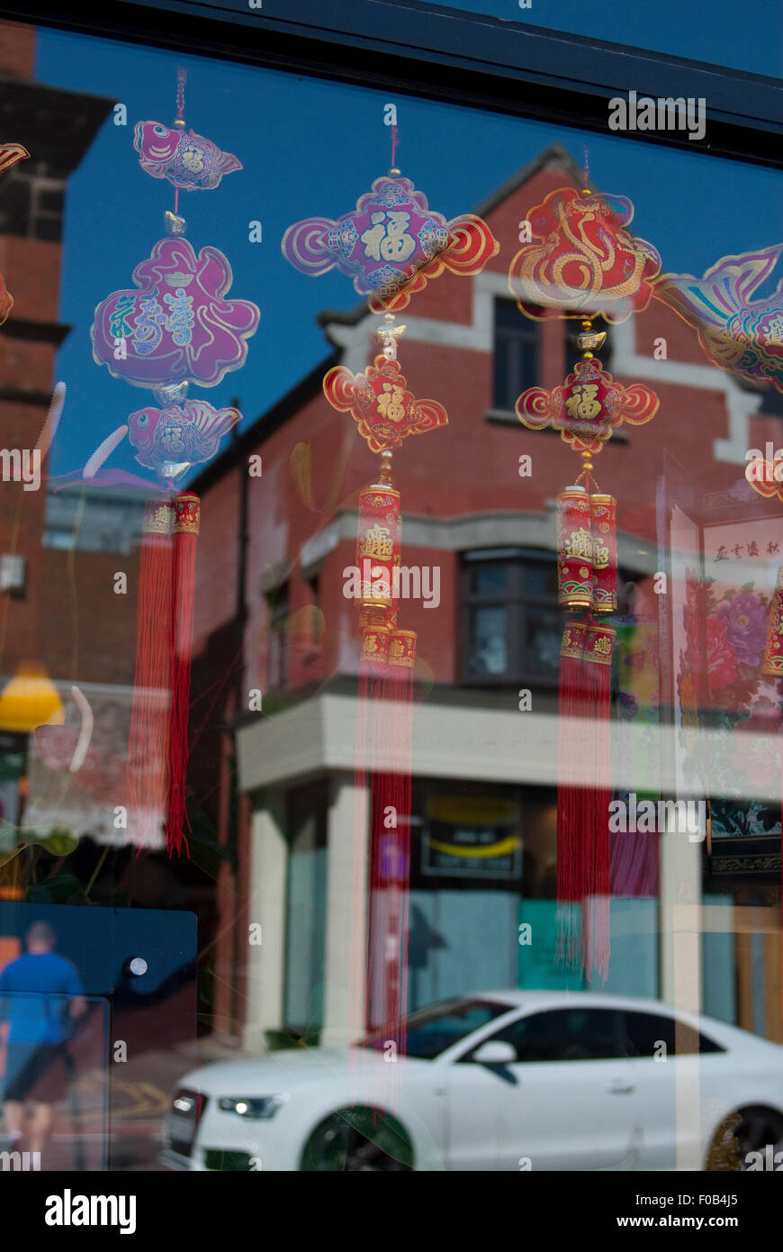 Editorial image taken in China town district of Liverpool of a car and building reflected in a window Stock Photo