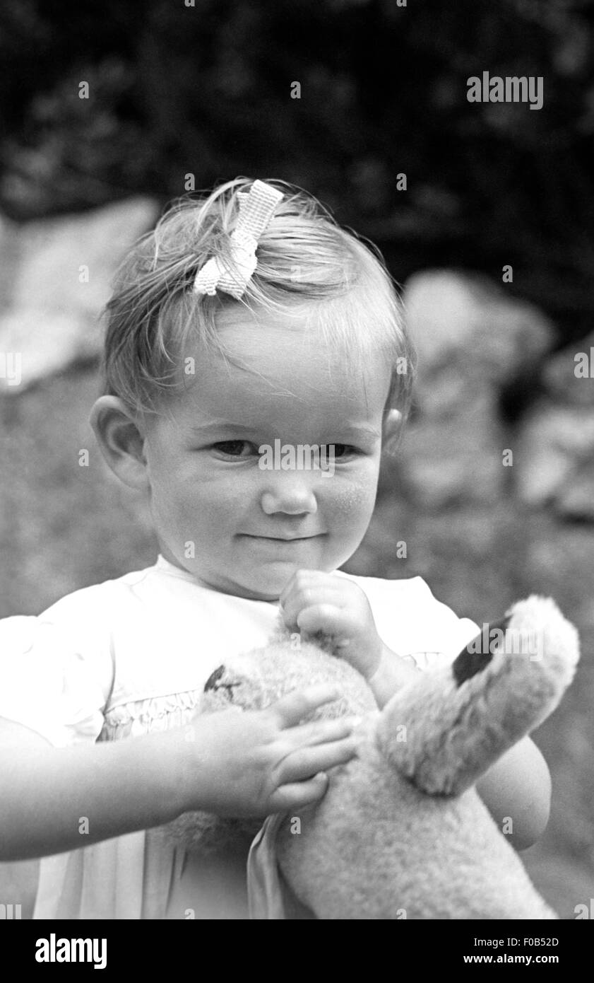 Baby girl holding her teddy bear Stock Photo - Alamy