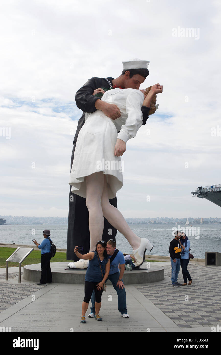 Tourists pose for pictures / selfies in front of a statue on the Embarcadero on the Waterfront in San Diego, California Stock Photo