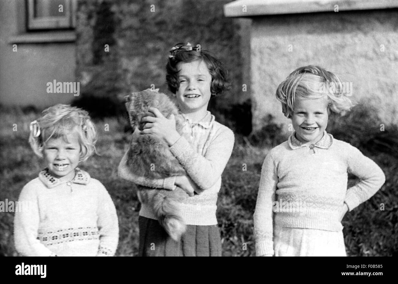 Three girls, one of them of holding a cat Stock Photo