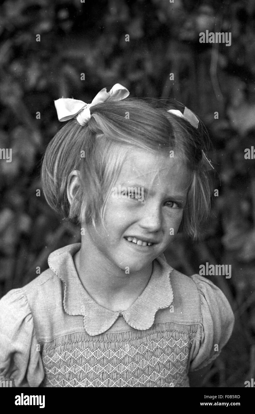 A young girl sitting on the grass in a garden Stock Photo - Alamy
