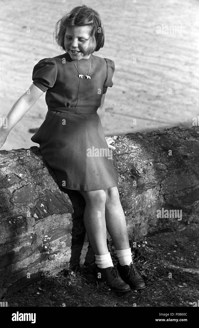 A young girl with a windswept hair and a smart dress Stock Photo