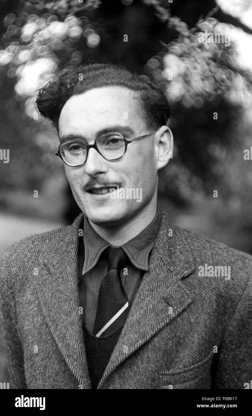 A man with swept back hair wearing a herringbone suit Stock Photo