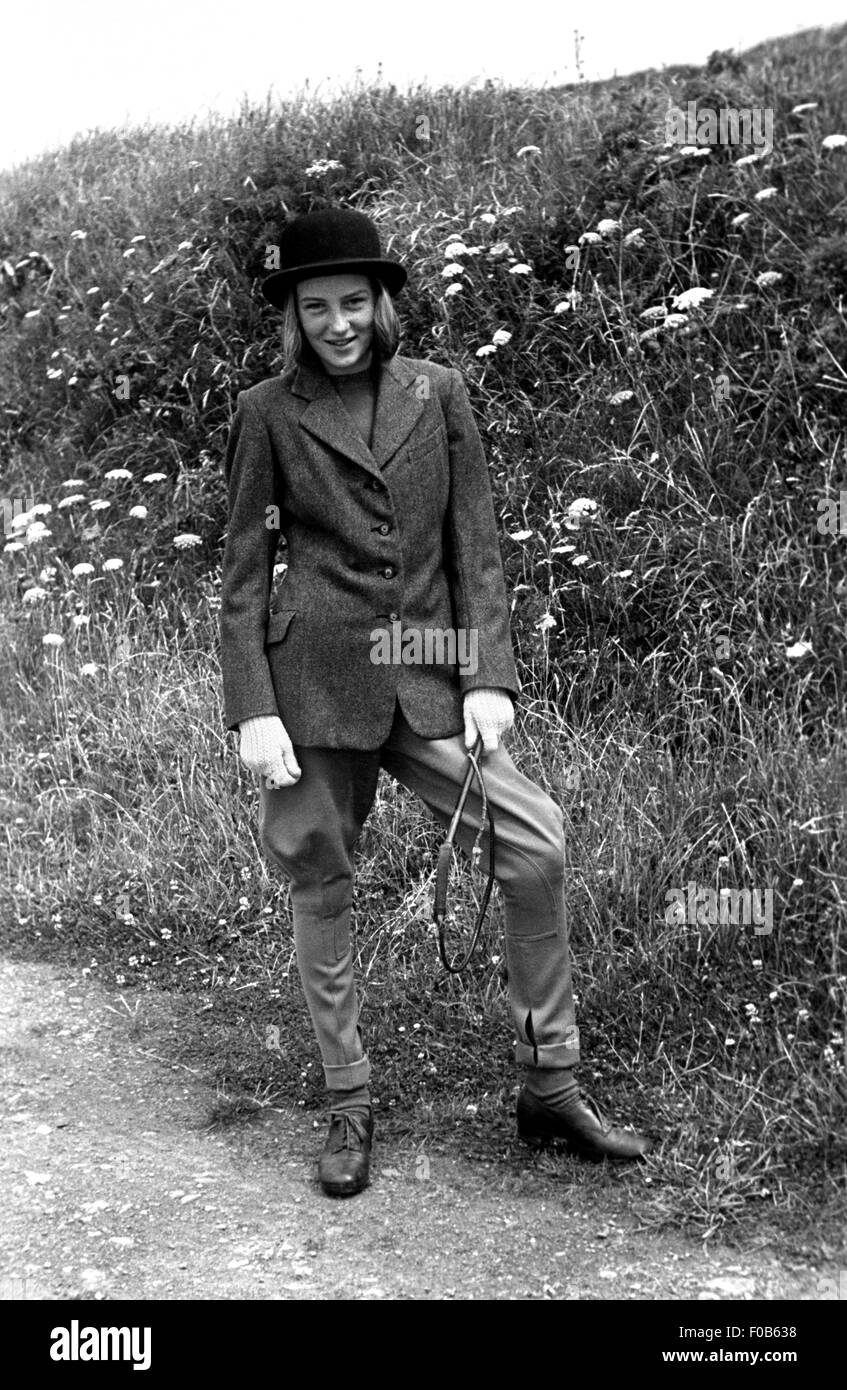 A young girl in riding gear, jacket, bowler hat and jodhpurs holding a  small whip Stock Photo - Alamy