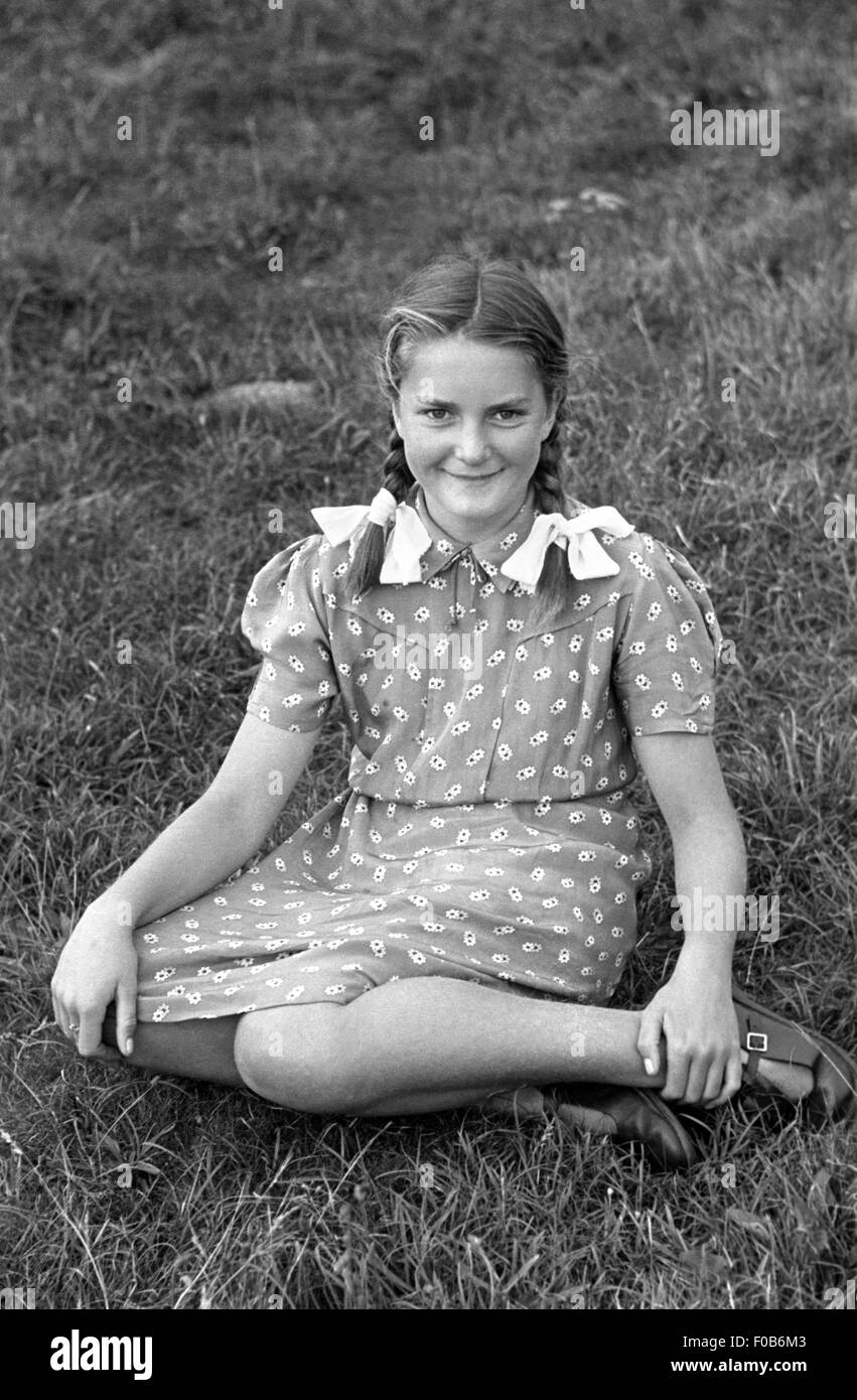 A young girl sitting in a field Stock Photo - Alamy