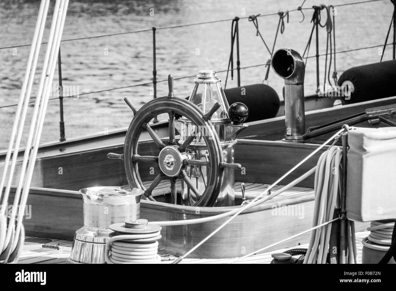 On the deck of an ancient luxury yacht, detailed view of the steering wheel surrounded by chords and other equipments Stock Photo