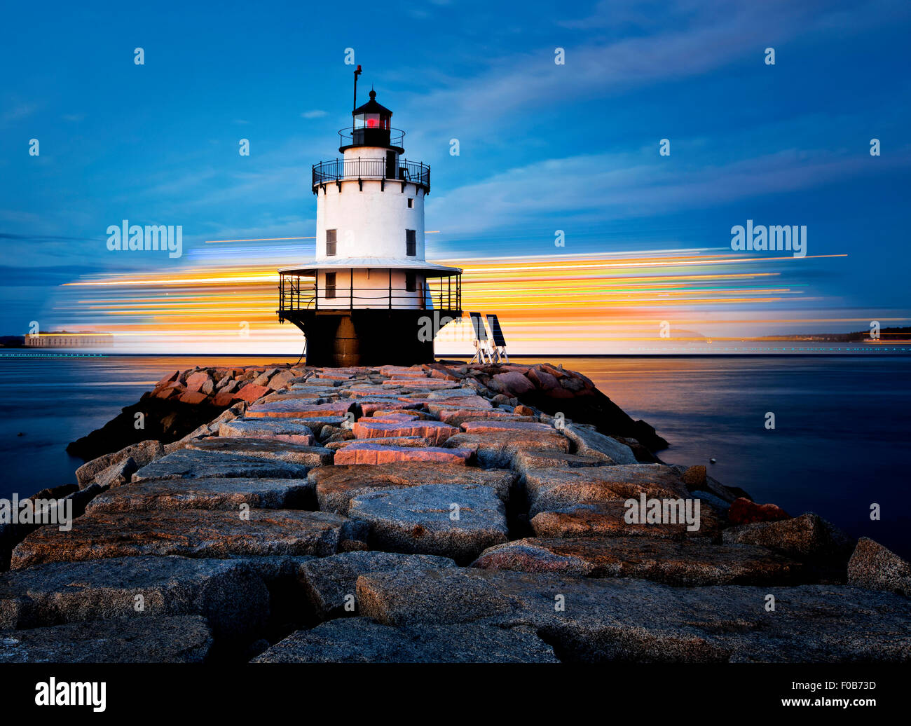 Lighthouse on top of a rocky island slow exposure Stock Photo