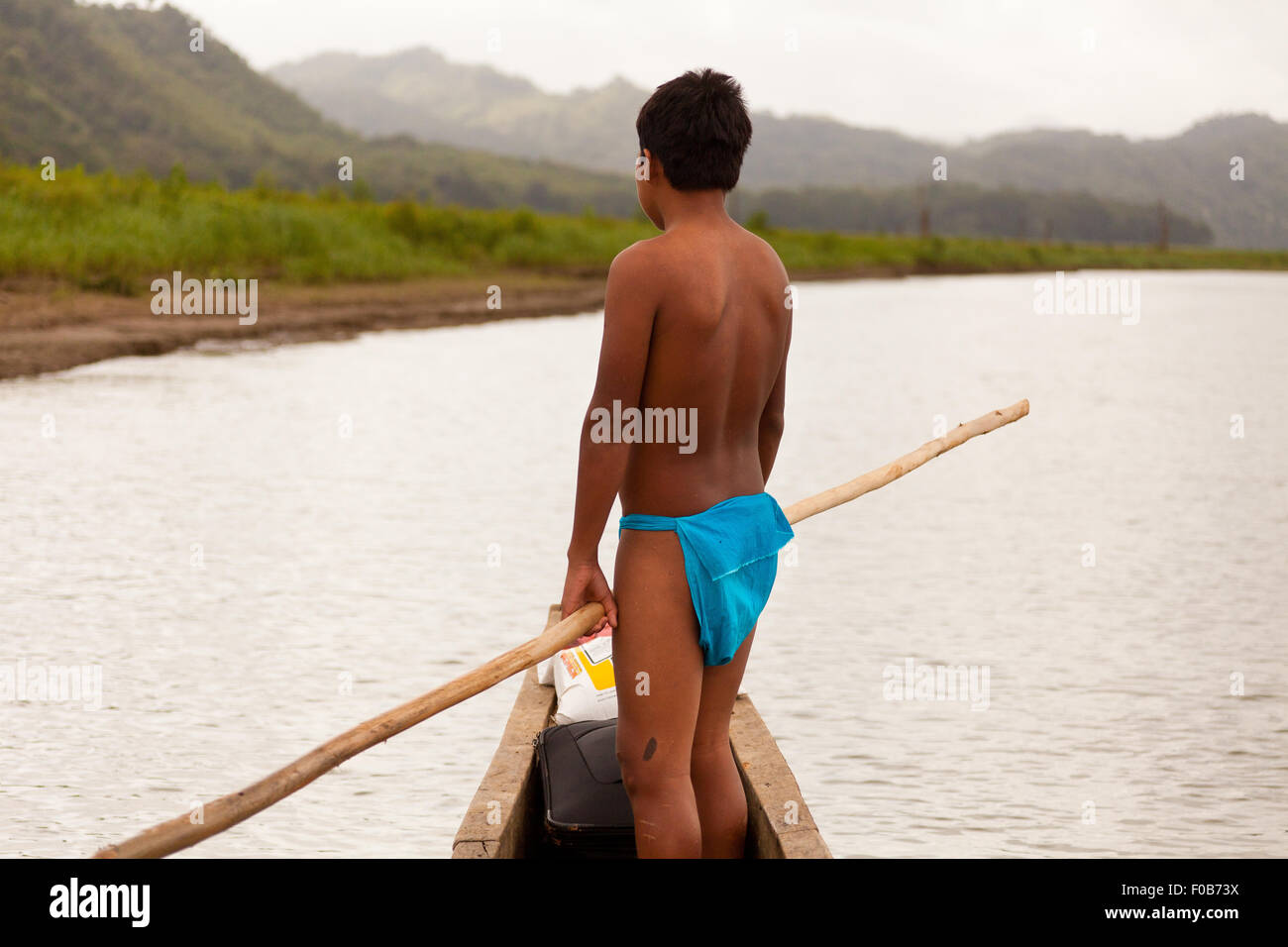 Young Embera indian boy in a dugout canoe traveling on Lago Alajuela and Rio Pequeni, Republic of Panama. Stock Photo