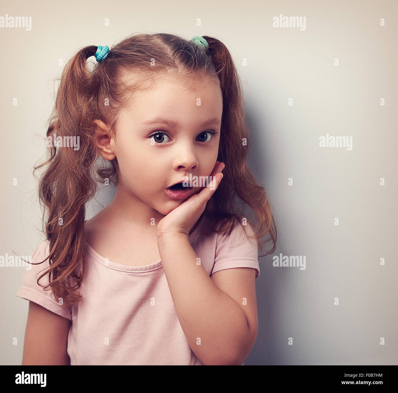 Surprising cute kid girl with open mouth looking serious. Vintage portrait Stock Photo