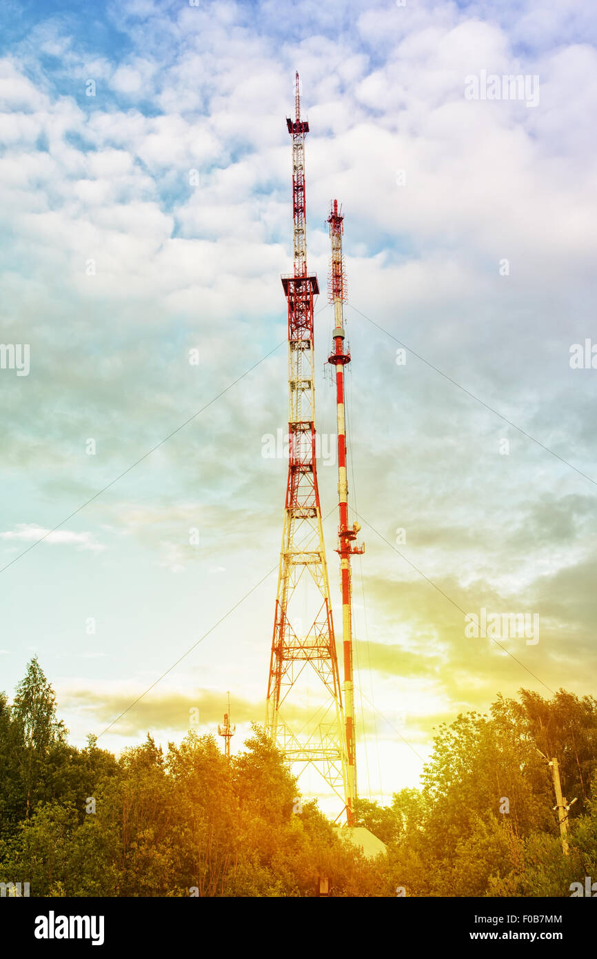 Two communication towers against a cloudy sky Stock Photo