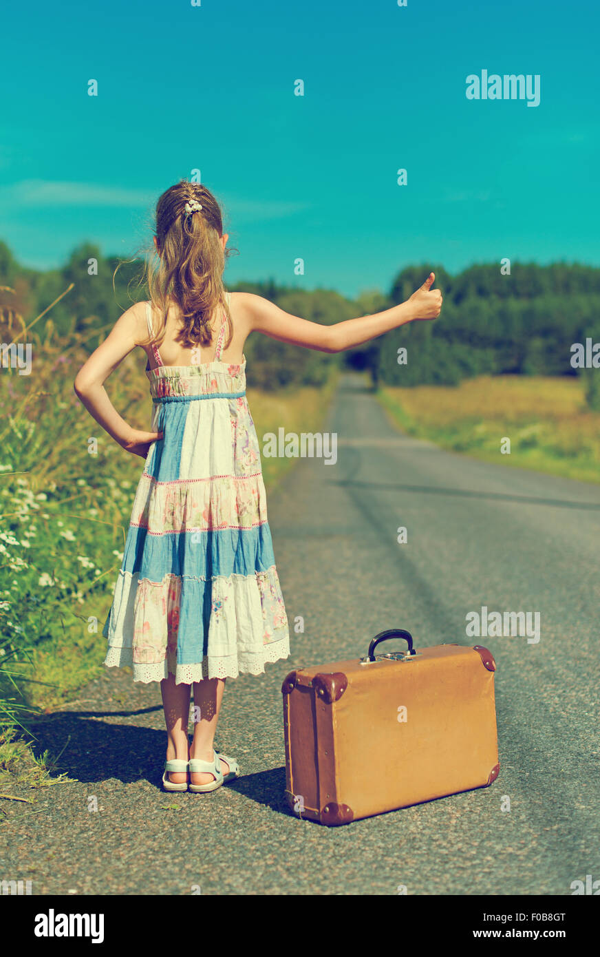 Little girl with vintage suitcase on rural road Stock Photo Alamy