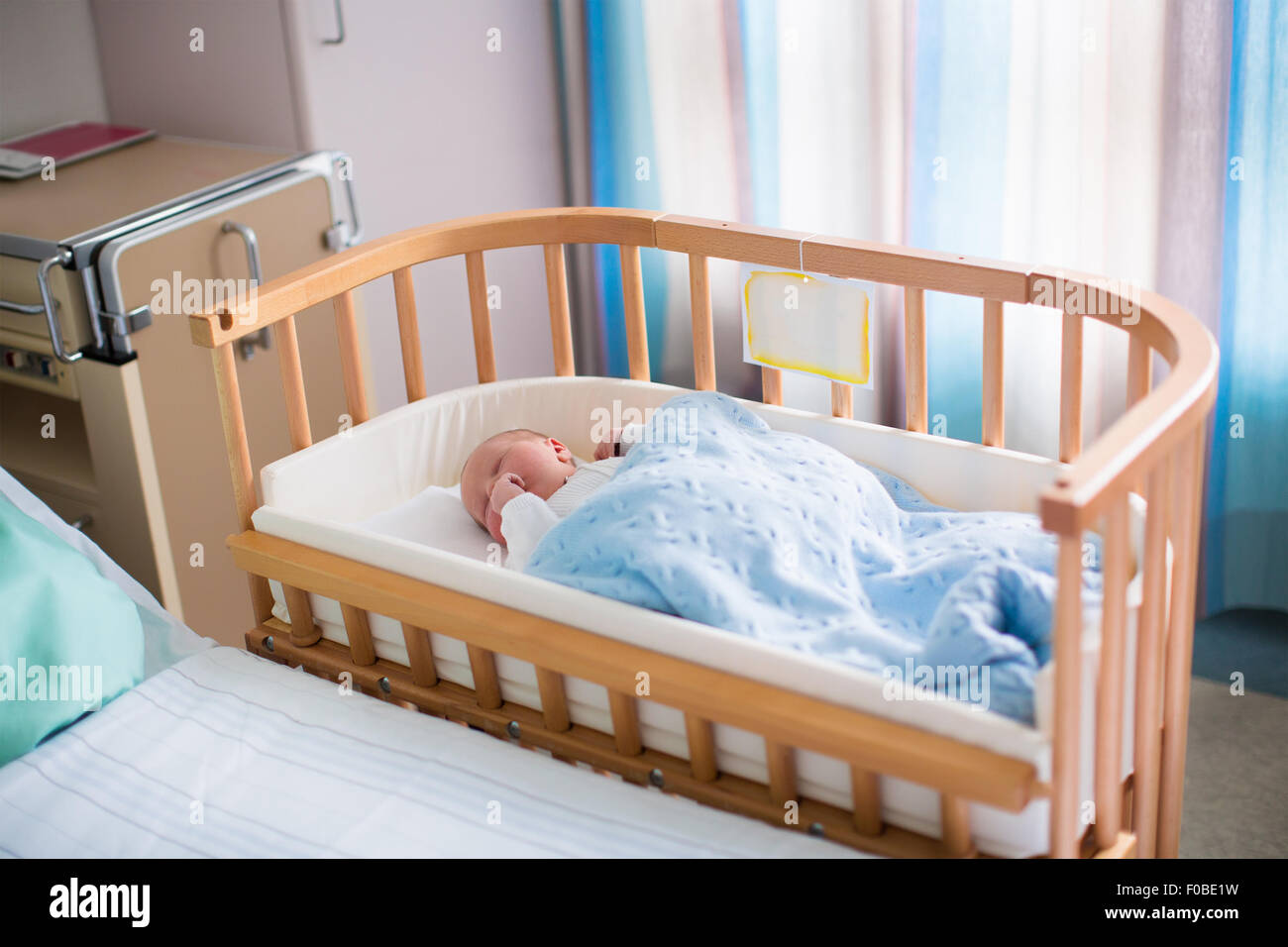 opladen segment Beheren Newborn baby boy in bed. New born child sleeping under a blue knitted  blanket. Children sleep. Bedding for kids Stock Photo - Alamy