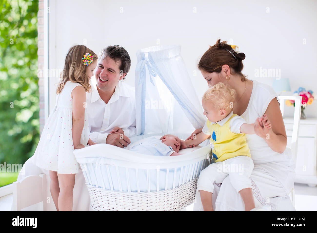 Big family with four kids in white bedroom. Parents and kids standing