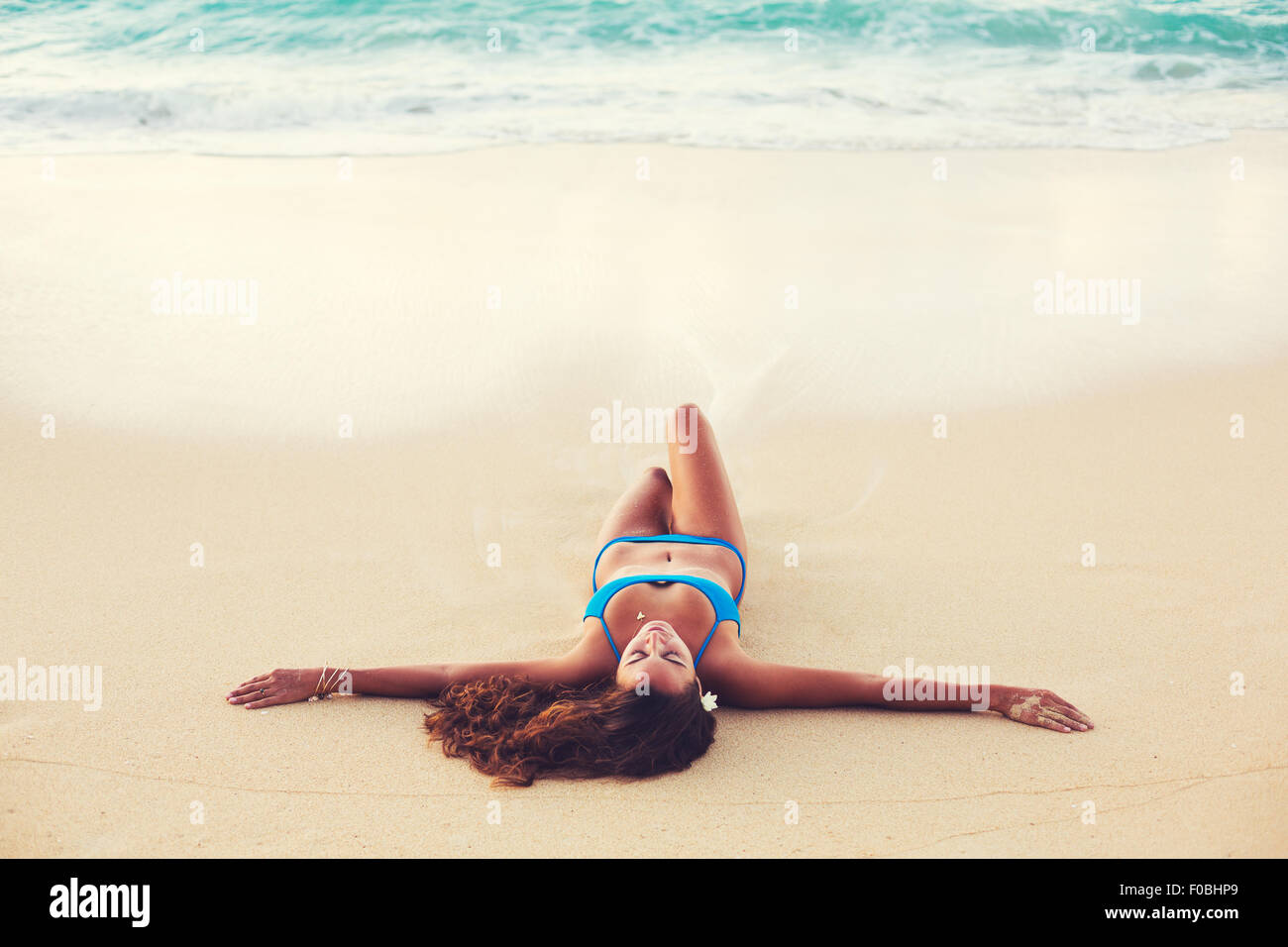 Summer Lifestyle, Beautiful Happy Carefree Young Woman Relaxing on the Beach at Sunset Stock Photo