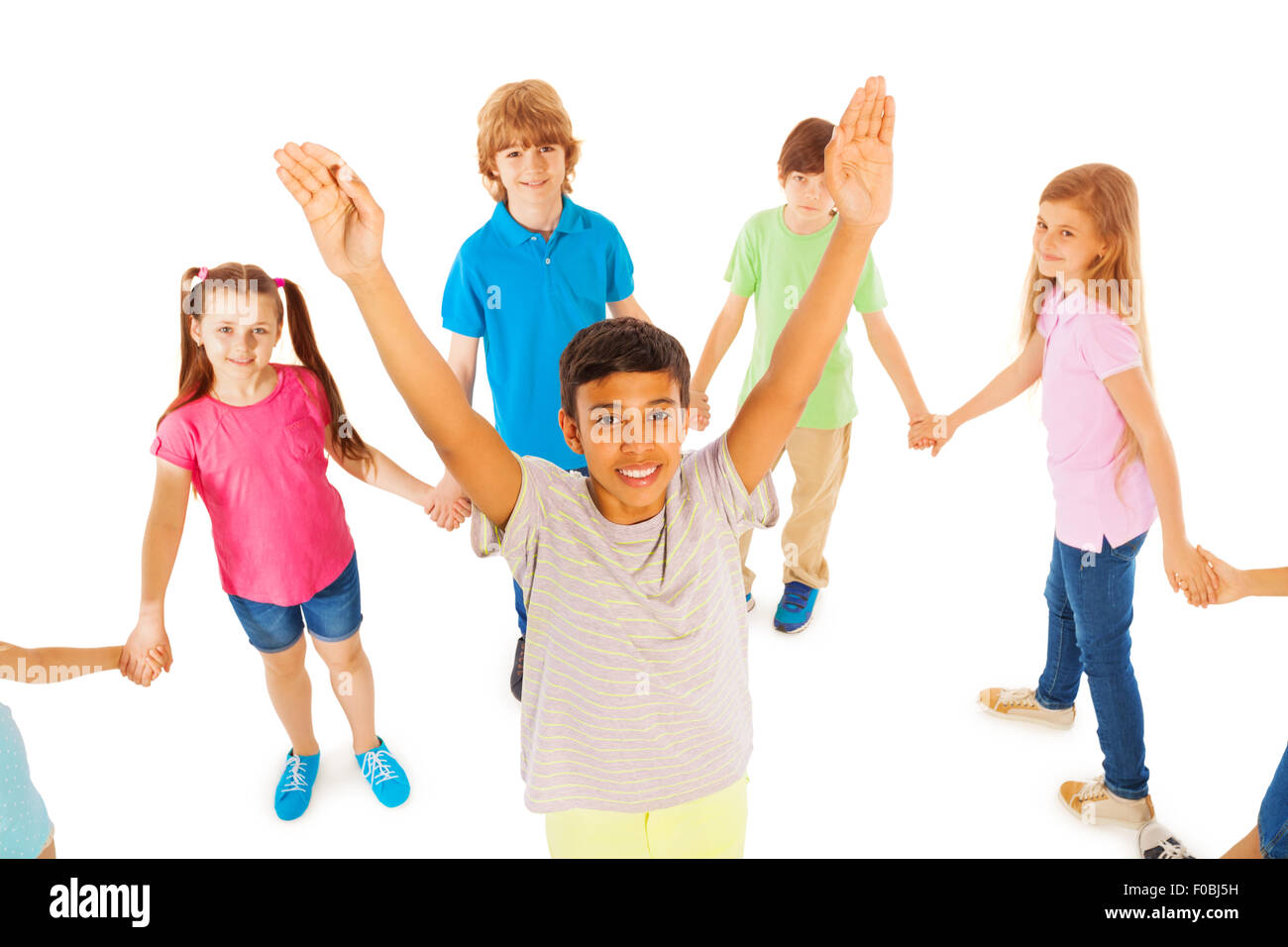 Boy with lifted hands stand in circle of friends Stock Photo